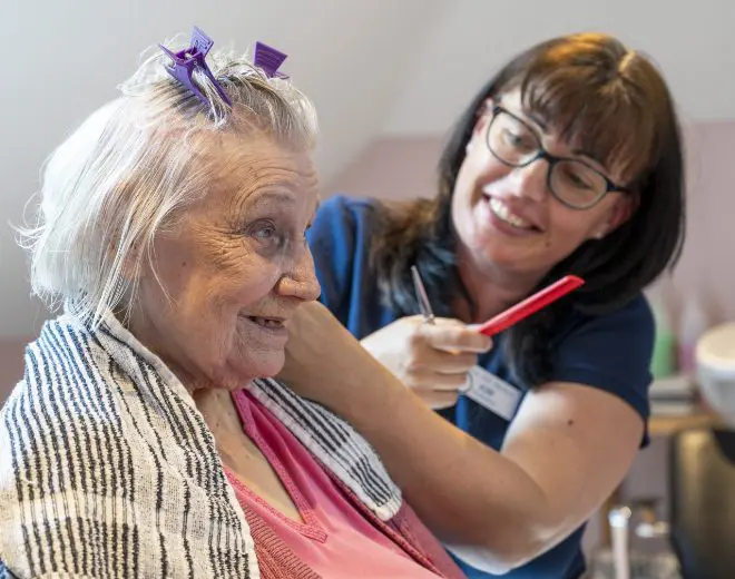 ACI Care | A resident at Old Rectory Care Home Dymchurch enjoying a hair styling session, receiving personal care under our care.