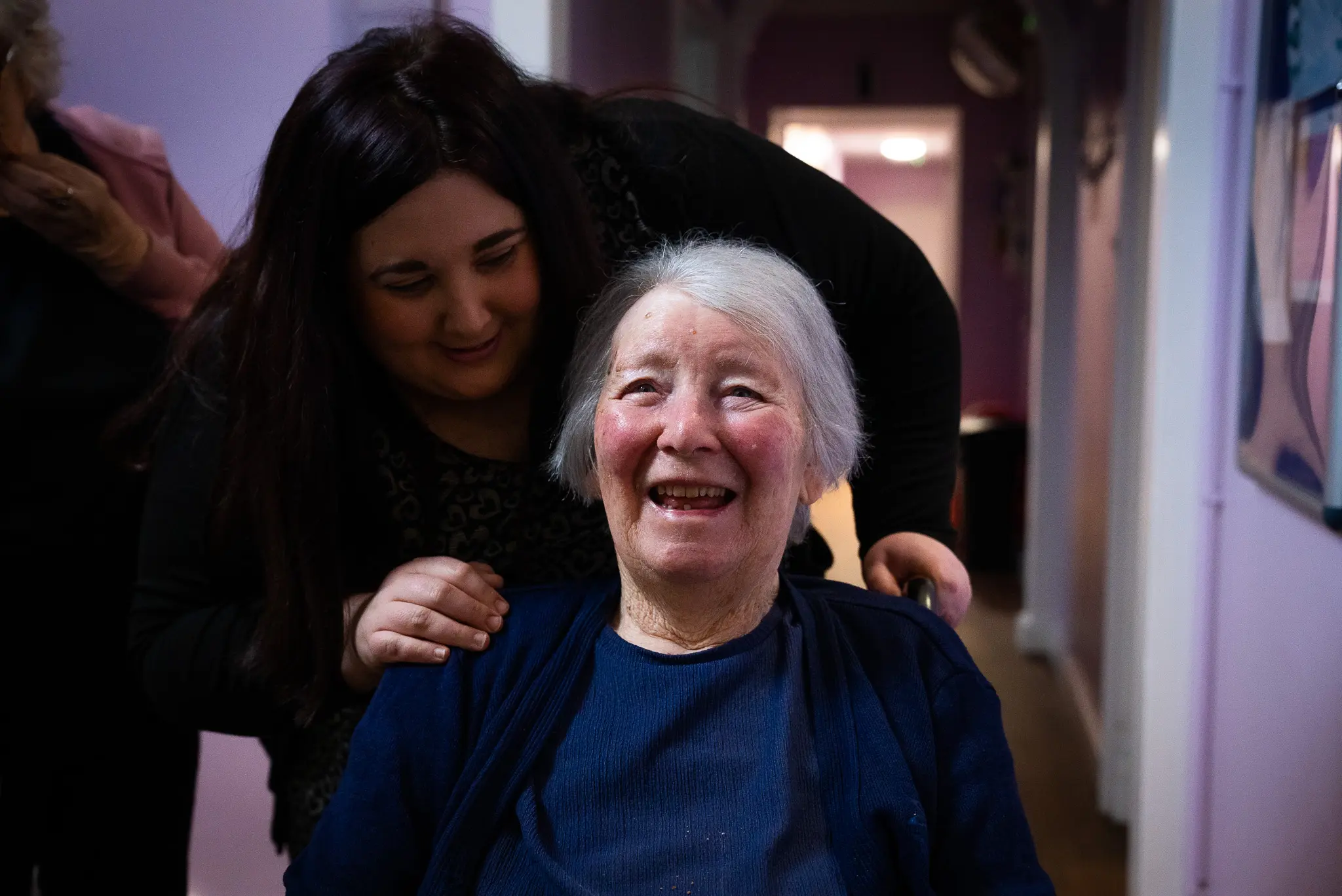 ACI Care | A resident smiling and laughing, enjoying a moment of happiness and comfort under our care.