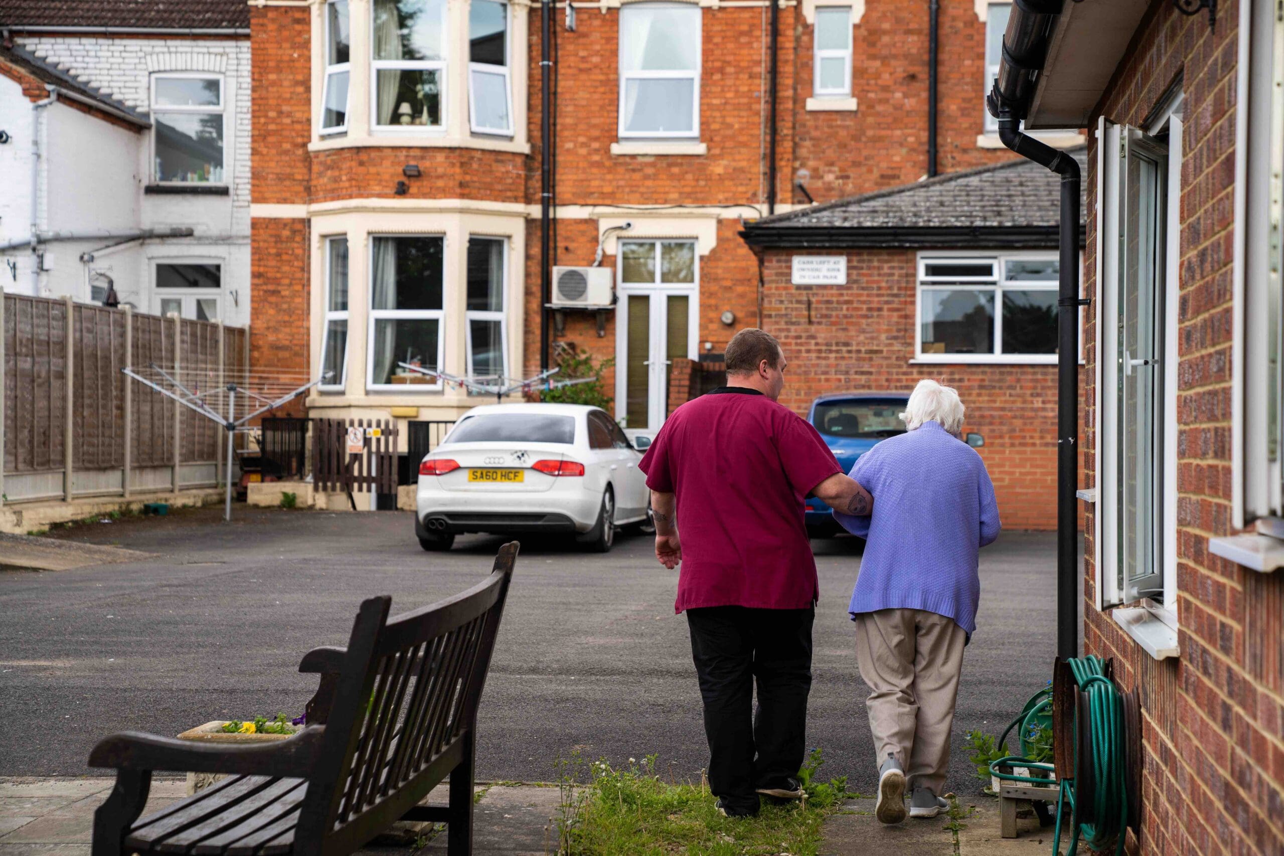 A resident walking outside with a care worker
