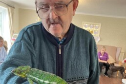 A resident holding a chameleon