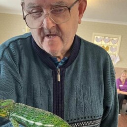 A resident holding a chameleon