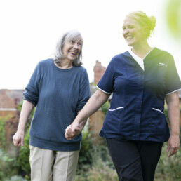 Best Social Activities for the Elderly | A resident walking with a care worker outside