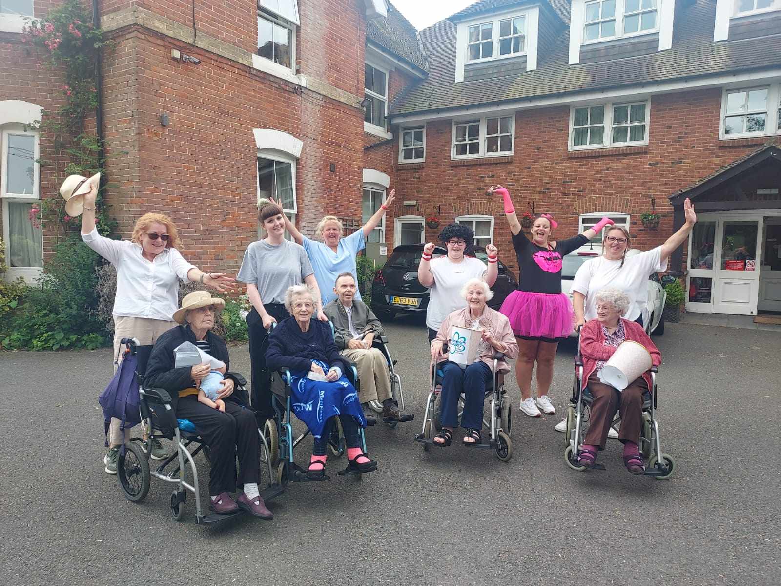 Staff and residents raising their arms in delight following the walk