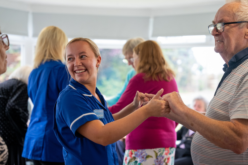 resident and carer dancing 