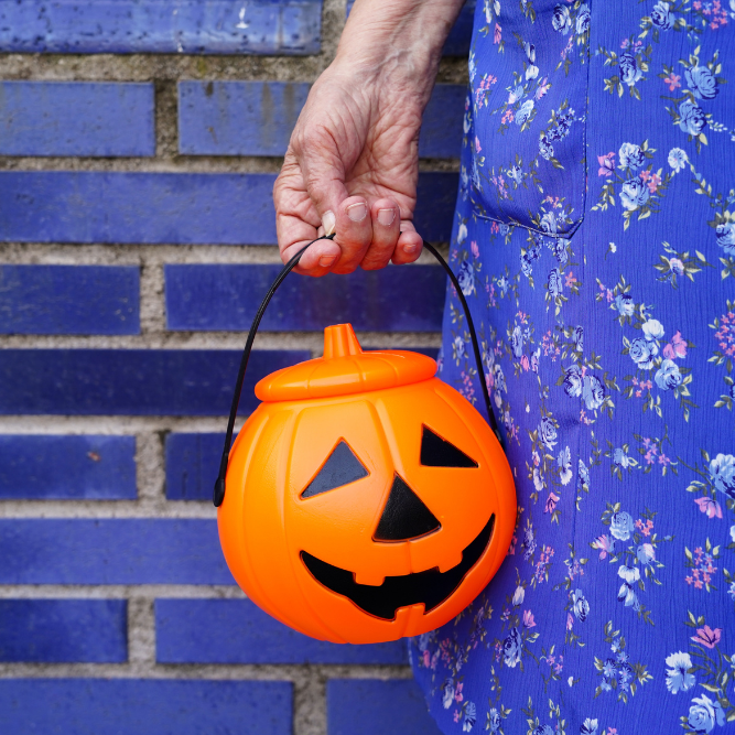 Older Adult Holding Trick or Treat Bucket