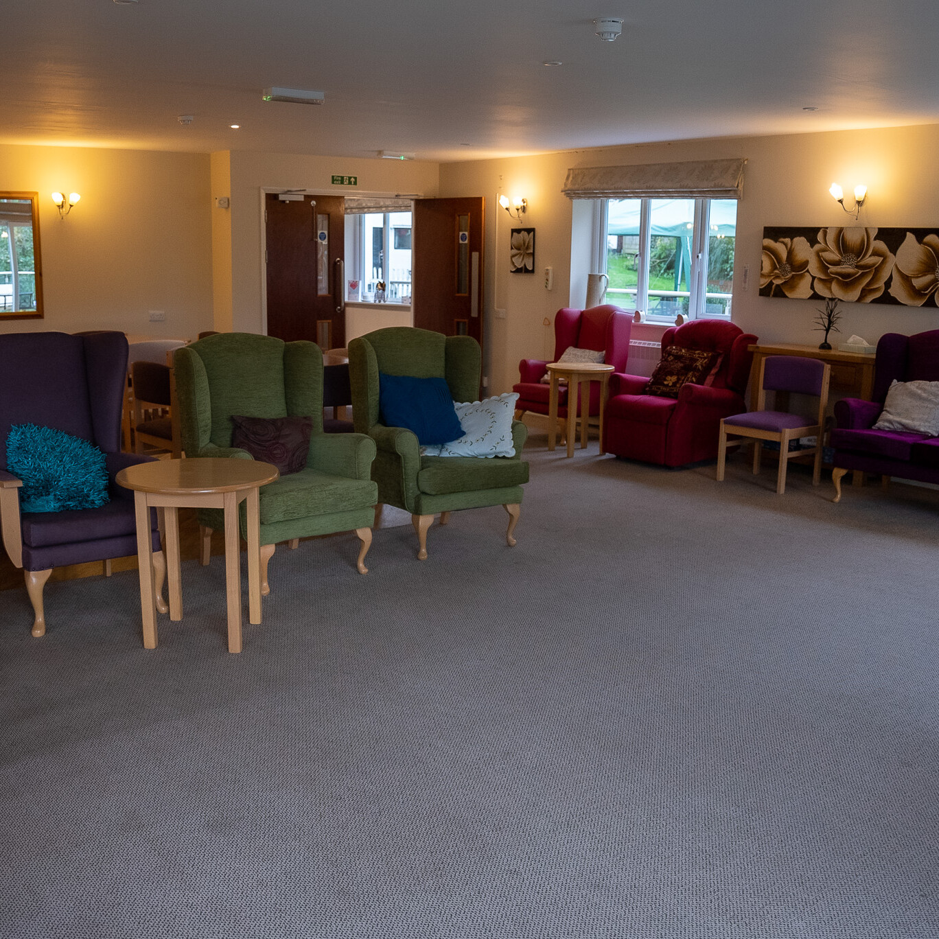 ACI Care | A wide-angle view of the communal lounge at Mountside Care Home Hastings, offering a cozy and inviting space for residents to relax and socialize.